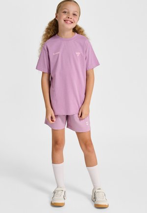 Lila katoenen t-shirt met korte mouwen en logo, gecombineerd met bijpassende korte broek. Witte sokken en sneakers met beige zolen maken de look compleet.
