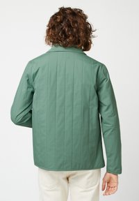 Groene gewatteerde jas met een kraag, lange mouwen en een gestroomlijnd ontwerp. Beschikt over een gladde textuur en uniforme stiksels over de rug.