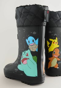 Zwarte rubberen regenlaarzen met kleurrijke Pokémon-personages: Squirtle, Bulbasaur, Pikachu en Charmander. Gequilt bovenwerk in zwart.