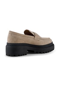 Beige suede loafers with a rounded toe, a stitching detail, and a thick black rubber sole with ridges for traction.