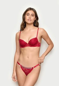Rød blond BH og matchende trusse med satin detaljer. BH'en har polstrede skåle og justerbare stropper; trussen inkluderer dekorative metaldele.