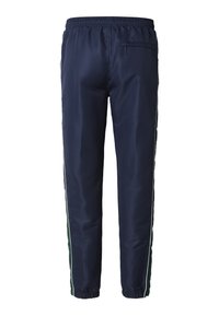 Námořnicky modré teplákové kalhoty z hladké tkaniny, s bílými a zelenými bočními pruhy, elastickým pasem a zipovou kapsou na zadní straně.