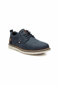 Zapato de cuero azul marino con puntera redonda, detalles en marrón contrastante y suela de goma blanca; presenta cierre de cordones y costuras decorativas.