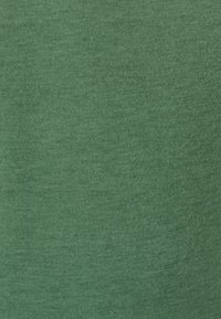 Tessuto di cotone verde con una consistenza liscia, caratterizzato da un colore uniforme e trame sottili, adatto per abbigliamento o abbigliamento casual.