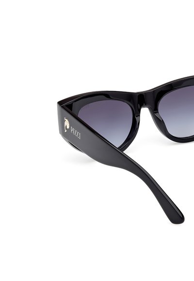 Svarta plastkatteögon-solglasögon med graduerade linser, med en guld Pucci-logga på sidan, slät yta och vinklig design.