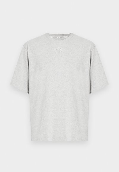 Pelēka īsroku T-krekls no mīksta auduma. Aprīkots ar apaļu kakla izgriezumu un nelielu apaļu logotipa detaļu priekšpusē. Vienkāršs un brīvs piegriezums.
