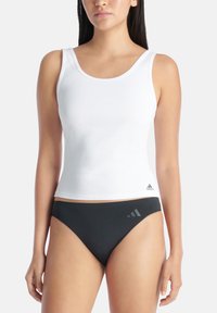 Biała ribbed top bez rękawów z szerokimi ramiączkami, ozdobiona małym czarnym logo Adidasa, w zestawieniu z czarnym dołem bikini z detalami w postaci trzech pasków.