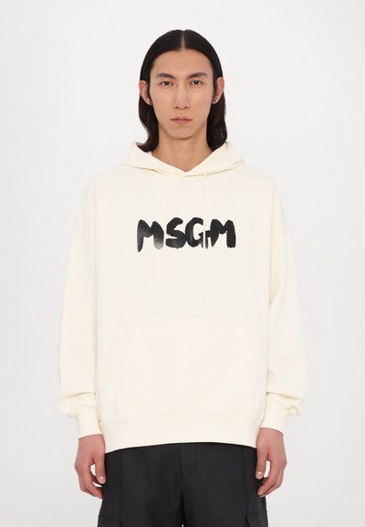 Un sweat à capuche crème avec un grand graphique noir "MSGM" sur le devant, doté d'une poche kangourou et d'une capuche avec cordon de serrage ajustable.