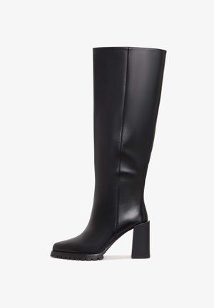 Schwarze kniehohe Stiefel aus glattem Leder. Mit quadratischer Zehenpartie, klobigem Blockabsatz und einer strukturierten Gummisohle für guten Halt.
