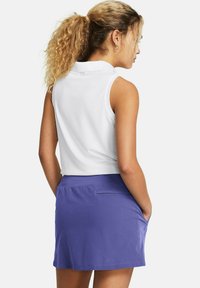 White sleeveless polo shirt paired with a purple skirt featuring a back pocket. The shirt has a classic collar and a smooth texture.