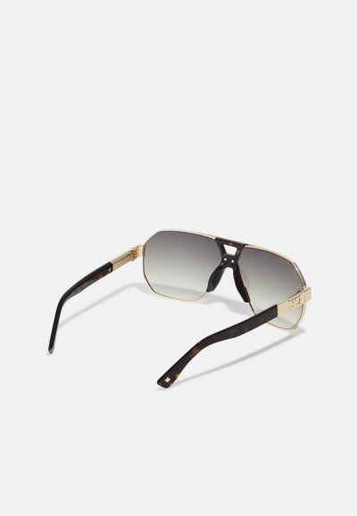 Gold metal frame sunglasses with octagonal lenses, gradient tint, and dark tortoiseshell arms featuring subtle branding accents.