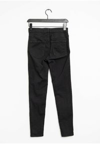 Jeans negros ajustados con una textura suave, que cuentan con dos bolsillos traseros, una cintura estándar y un diseño minimalista.