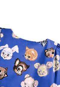 Modrý textil s hravým zvířecím vzorem, který zobrazuje stylizované tváře různých zvířat, včetně králíků, koček a jelena.