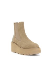Bottine en suède beige avec panneaux latéraux élastiques, semelle compensée et bout arrondi. Caractéristiques d'une texture lisse et d'une semelle en caoutchouc robuste.