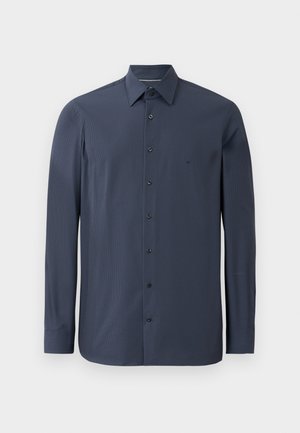Mørkeblå langermet skjorte laget av glatt stoff, med krage som kan kneppes ned og svarte knapper langs fronten. Subtil teksturdetalj synlig.