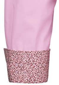 Tessuto rosa con una manica a motivi floreali in tonalità rosa, maroon e azzurro chiaro. Texture liscia; design aderente. La manica aggiunge un dettaglio decorativo.