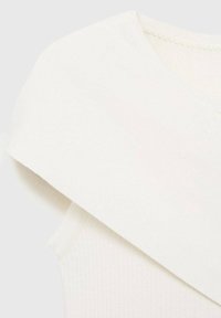 Ljust färgad plagg med en bred, draperad krage, som visar en mjuk tygtextur och ribbat detalj vid halsringningen.