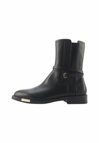 Botte cheville en cuir noir avec un bout rond, une sangle latérale avec une quincaillerie dorée et une finition lisse sur une semelle plate.