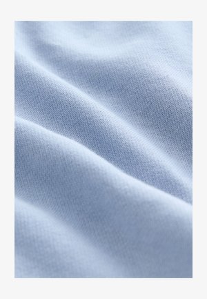 Tessuto azzurro chiaro con una texture morbida e liscia, caratterizzato da fini motivi lavorati a maglia e pieghe delicate che aggiungono profondità alla superficie.