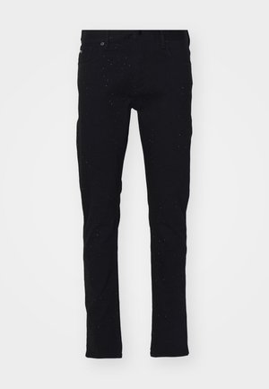 Črne skinny jeans iz denima z rahlo zbledelim videzom. Imajo srednje visok pas, pet žepov in subtilne pikčaste detajle na nogah.