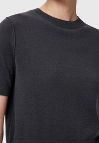 Dark gray short-sleeve sweater made from a smooth knit fabric. Features a crew neckline and ribbed cuffs, offering a minimalist design.