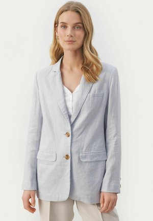 Světle šedý lněný blazer s dvěma knoflíky, klopovými límci a dvěma předními kapsami. Má jemnou texturu a minimální detaily prošívání.