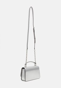 Sac à main métallique argenté avec une chaîne, de forme rectangulaire structurée, texture lisse et couture décorative le long des bords.