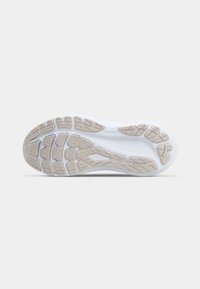 Semelle de chaussure de sport blanche avec un design en caoutchouc texturé, présentant un motif de rainures et de crampons, améliorant l'adhérence et la flexibilité.