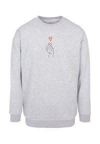 Gray sweatshirt made of soft material featuring a graphic of a hand making a heart shape, outlined in black with a red heart above it.