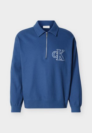 Pullover blu a maniche lunghe con collo, mezza cerniera, polsini e orlo a coste, con logo bianco "cK" sul petto a sinistra.