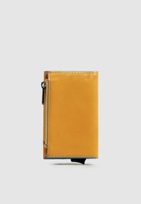 Portafoglio in pelle gialla con chiusura a zip, forma rettangolare, dettagli di cuciture blu, texture liscia e design compatto.