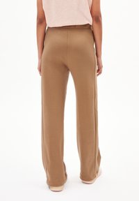 Pantalons larges bruns en tissu doux, avec une taille haute et sans motifs visibles. Texture lisse avec un design d écontracté.