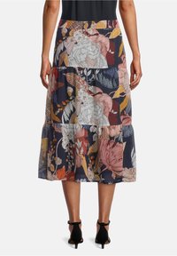 Blommig maxikjol med marinblå bakgrund och stora rosa och vinröda blommor, flerlagersdesign och en luftig textur.