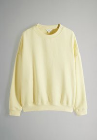 Gul överdimensionerad sweatshirt med rund hals, långa ärmar och ribbstickade muddarna, tillverkad av ett mjukt bomullsblandningsmaterial.