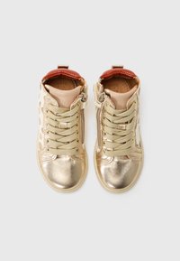 Gold metallic high-top sneakers with beige accents and a dotted pattern. Features a textured tongue and light gray laces. Side zip closure.