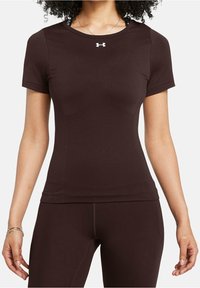 Brązowy sportowy t-shirt z krótkimi rękawami, okrągłym dekoltem i logo Under Armour na piersi. Wykonany z elastycznego, odprowadzającego wilgoć materiału.