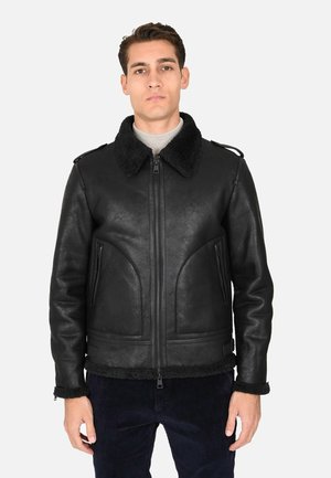Giacca in pelle nera con finitura testurizzata, colletto foderato in pelliccia, due tasche laterali e chiusura con zip. Presenta un design corto e polsini regolabili.