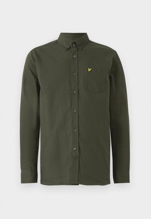 Chemise à manches longues vert foncé avec col boutonné, poche poitrine et petit logo d'oiseau brodé en jaune sur la poche.