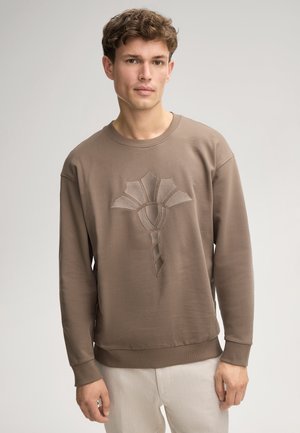 Felpa marrone in cotone con un design testurizzato ricamato che presenta una forma floreale stilizzata. Collo a giro e polsini a costine.