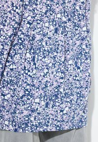 Bluse mit floralem Muster in Marineblau, Pink und Weiß. Mit Falten und einer glatten Textur, sowie einem runden Ausschnitt und kurzen Ärmeln.
