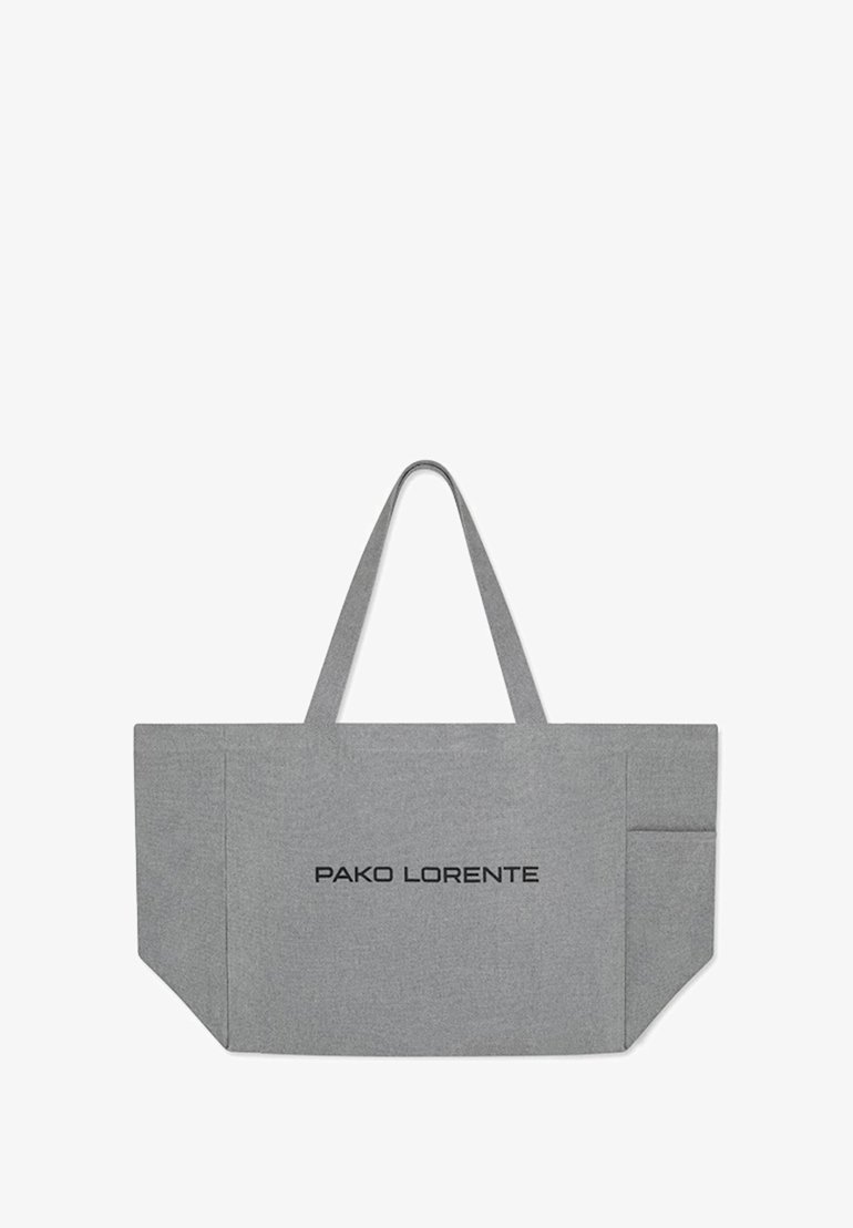 Szara torba materiałowa z dwoma ramiączkami, prostokątna, z wyraźnym czarnym logo "PAKO LORENTE" i kieszenią boczną.