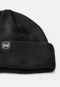 Gorro de punto negro con puño enrollado y una pequeña etiqueta circular del logo de Buff. La textura es suave y cuenta con un diseño ajustado y sin estructura.