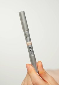 Crayon double embout argenté avec une pointe pêche clair et beige. Dispose d'un design élégant et du logo de la marque "KIKO MILANO" sur le corps.