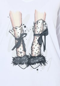 Grafik mit High Heels und transparenten, gepunkteten Strümpfen, verziert mit schwarzen Schleifen und Pelzakzenten, auf weißem Hintergrund.