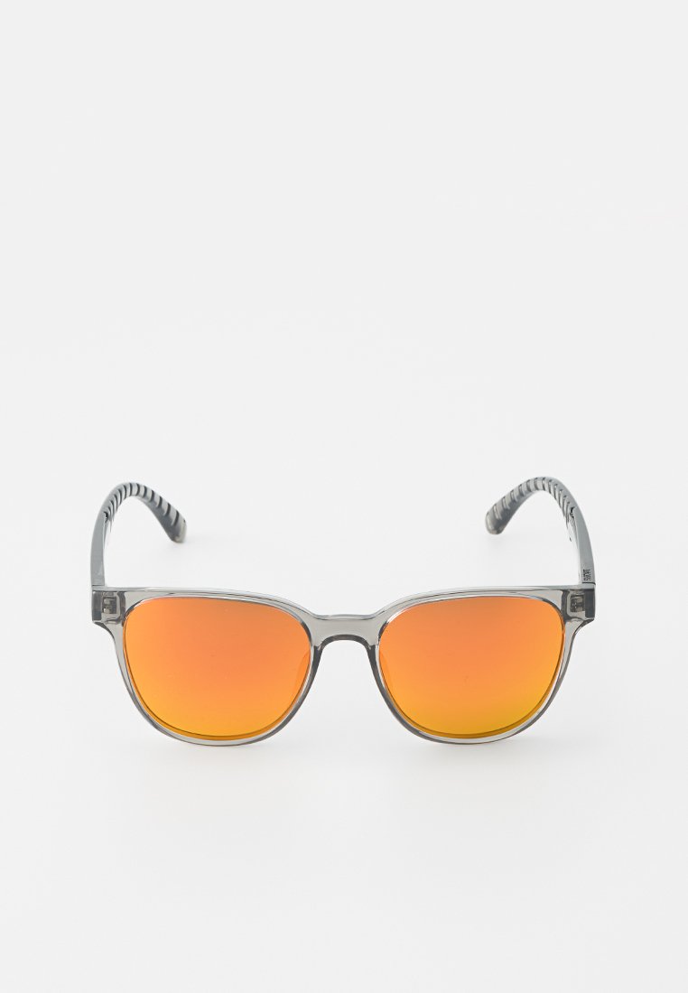 Okulary przeciwsłoneczne z transparentnymi szarymi oprawkami, pomarańczowymi gradientowymi szkłami i teksturowanymi czarnymi zausznikami. Prostokątny kształt, minimalistyczny design.