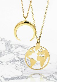 Collares en tono dorado que presentan un colgante de luna creciente y un colgante de globo; ambos tienen superficies lisas y diseños recortados intrincados.