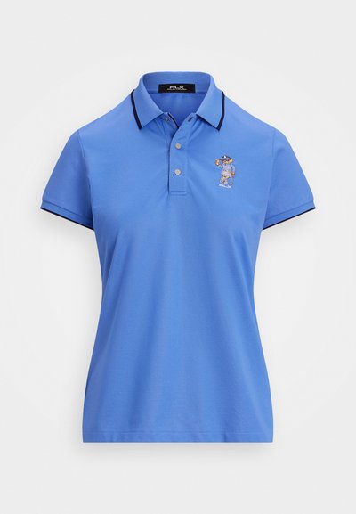 Gaiši zila polo krekls ar apkakli, divām pogām un tumši zilām malām. Uz kreisā krūšu puses ir mazs izšūts tēls. Mīksta tekstūra.