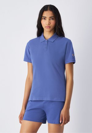 Camisa polo de algodón azul con cuello, dos botones y mangas cortas, combinada con pantalones cortos azules a juego con un diseño sencillo.