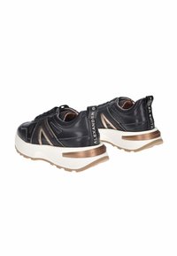 Sneakers in pelle nera con accenti in bronzo, suole bianche spesse, superficie testurizzata e dettagli con logo sul retro e sul lato.