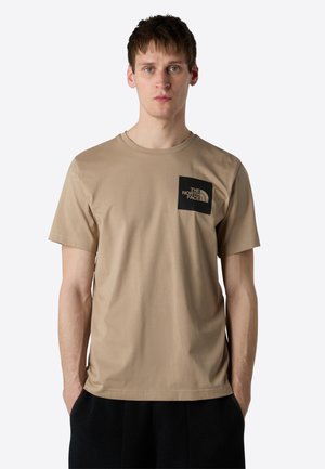 Beige bomuld t-shirt med korte ærmer, rund halsudskæring, venstre brystlomme med et sort logo. Glat tekstur, afslappet pasform.